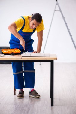 Genç erkek marangoz içeride çalışıyor.