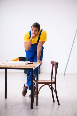 Genç erkek marangoz içeride çalışıyor.