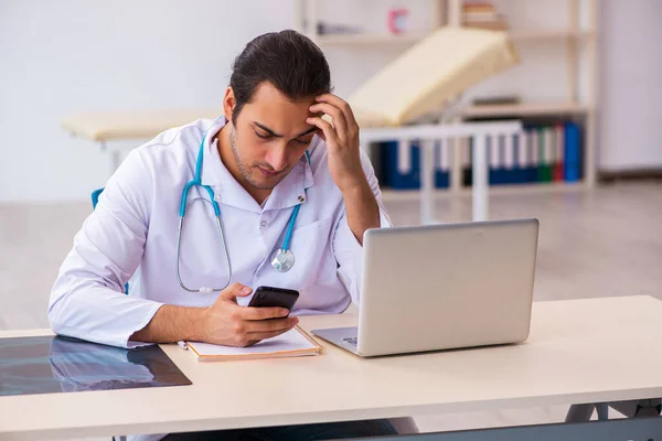 Jonge mannelijke arts werkzaam in de kliniek — Stockfoto