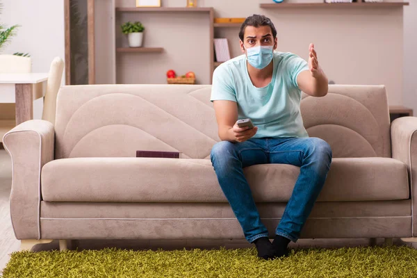 Jovem assistindo tv em casa durante pandemia — Fotografia de Stock