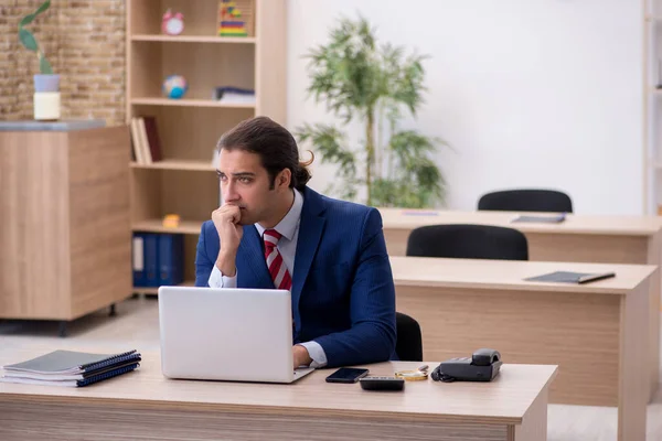 Junge männliche Angestellte sitzen im Büro — Stockfoto