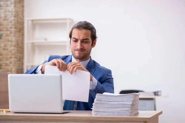 Junge männliche Mitarbeiter und zu viel Arbeit im Büro — Stockfoto