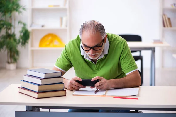 Anciano estudiante preparándose para los exámenes en el aula — Foto de Stock