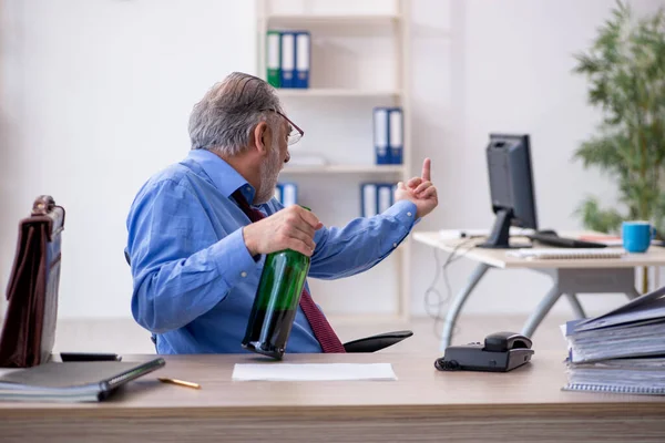 Un vieil employé boit de l'alcool au bureau — Photo