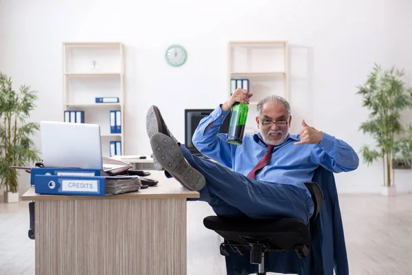 Un vieil employé boit de l'alcool au bureau — Photo