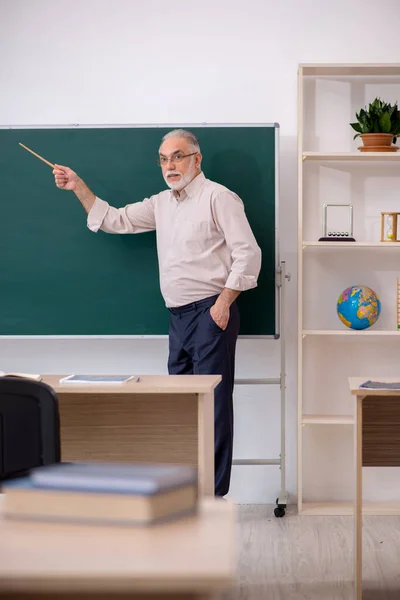 Old male teacher in front of blackboard — Stock Photo, Image