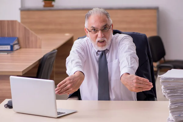 Alte männliche Angestellte unzufrieden mit exzessiver Arbeit im Büro — Stockfoto