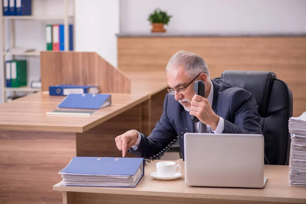 Öreg férfi alkalmazott elégedetlen a túlzott munka az irodában — Stock Fotó