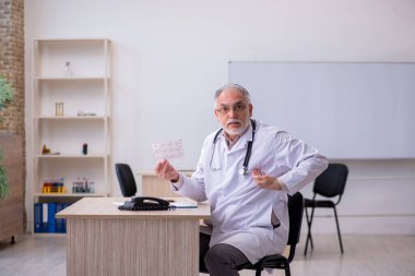 Klinikte çalışan yaşlı bir erkek kardiyolog.