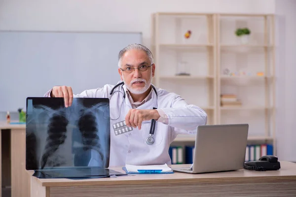 Starý lékař radiolog pracující na klinice — Stock fotografie