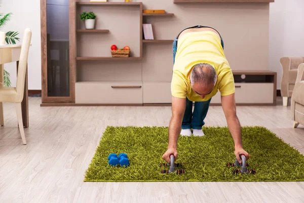 Yaşlı adam evde spor egzersizleri yapıyor. — Stok fotoğraf