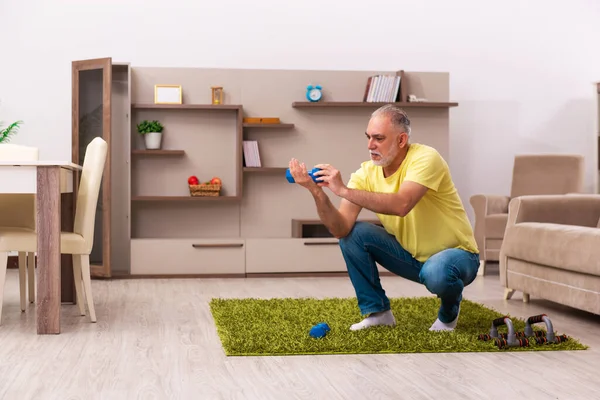 Homem idoso fazendo exercícios esportivos em casa — Fotografia de Stock