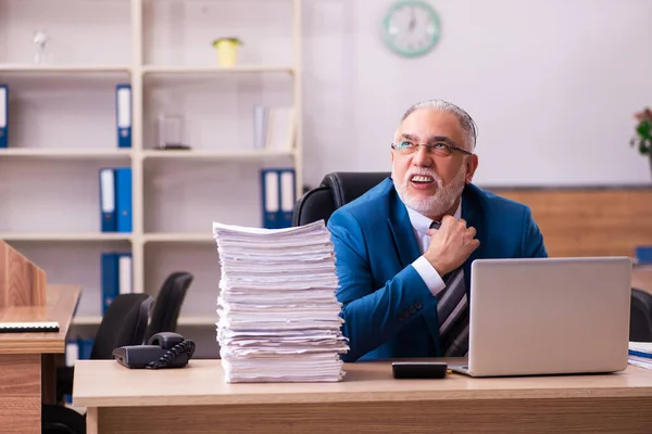 Gammal manlig anställd missnöjd med överdrivet arbete på kontoret — Stockfoto