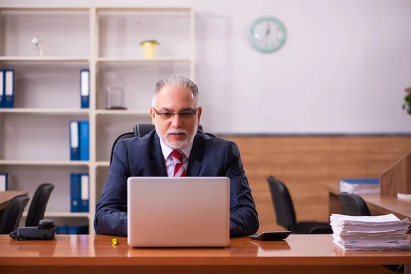 Gammal manlig anställd som sitter på kontoret — Stockfoto