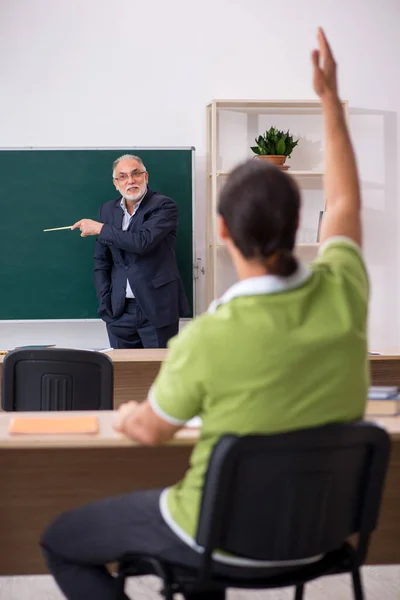 Ältere Lehrer und junge männliche Schüler im Klassenzimmer — Stockfoto