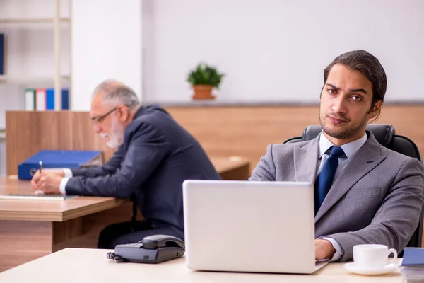 Old boss and young male assistant in the office — Stock Photo, Image