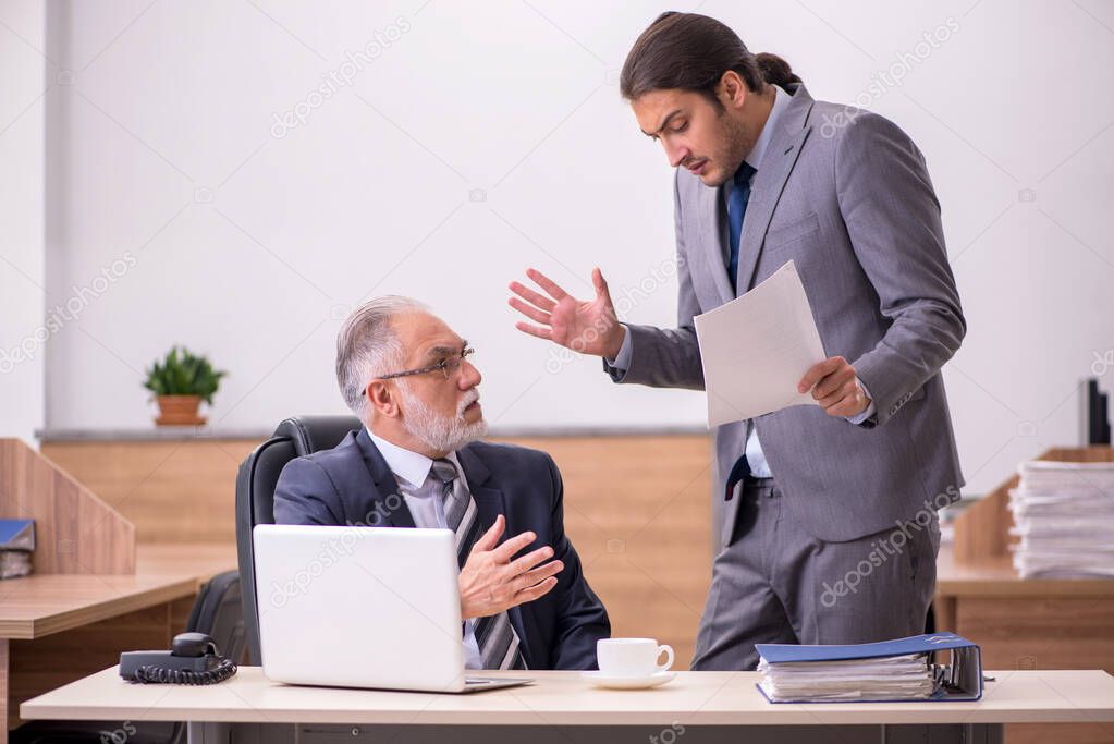 Old boss and young male assistant in the office