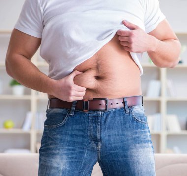 Diyet konseptinde fazladan ağırlık çeken adam.