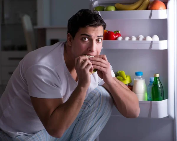 Ο άντρας στο ψυγείο τρώει τη νύχτα. — Φωτογραφία Αρχείου