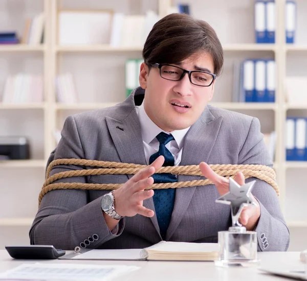 Businessman tied up with rope in office — Stock Photo, Image