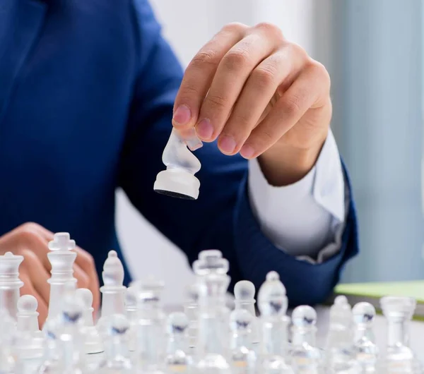 Jovem empresário jogando xadrez de vidro no escritório — Fotografia de Stock