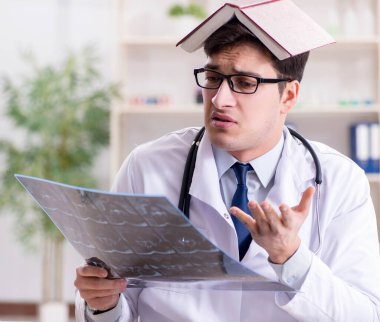 Genç doktor klinikteki röntgen görüntülerine bakıyor.