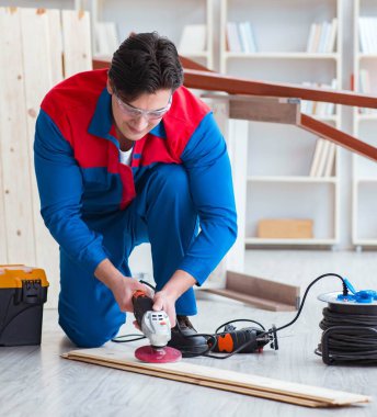 Genç marangoz tahta kalaslarla çalışıyor.