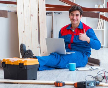 Dizüstü bilgisayarı olan genç bir marangoz