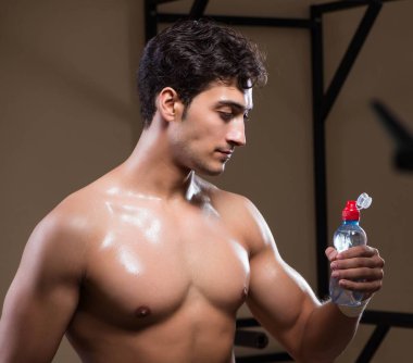 Spor salonunda su içen susamış bir adam.