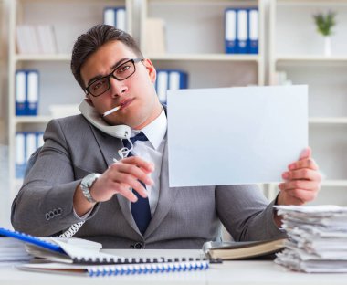 Ofiste sigara içen bir iş adamı elinde boş bir mesaj tutuyor.