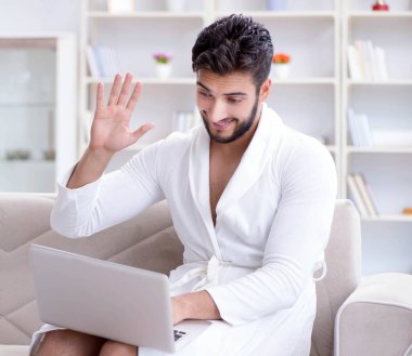 Evde dizüstü bilgisayarla çalışan serbest çalışan genç adam.