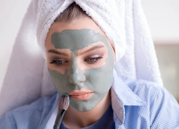 Kvinna tillämpa lera mask med borste hemma — Stockfoto