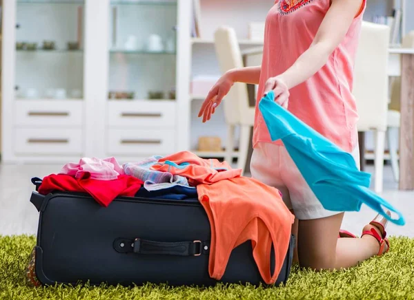 Mujer tratando de encajar toda la ropa para suitacase antes de las vacaciones —  Fotos de Stock
