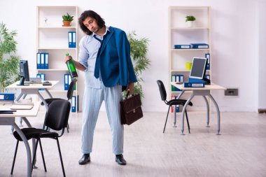 Erkek çalışan partiden sonra işe geliyor.