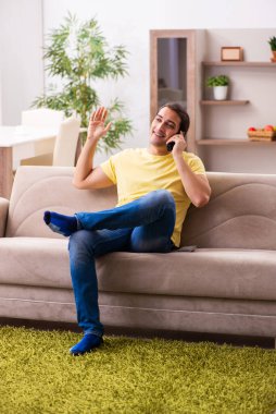 Evde telefonla konuşan genç bir öğrenci.