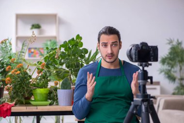 Evin içinde bitkileri olan genç bir erkek bahçıvan.