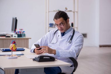 Klinikte çalışan genç bir erkek kardiyolog.