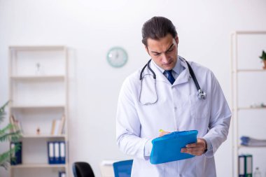 Klinikte çalışan genç bir erkek kardiyolog.