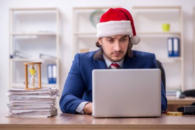 Noel arifesinde ofiste çalışan genç bir erkek işçi.