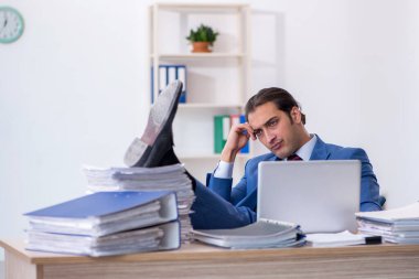 Ofisteki aşırı işten memnun olmayan genç bir erkek işçi.