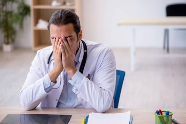 Klinikte çalışan genç erkek doktor.