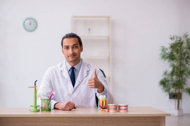 Genç erkek doktor stomatolojist klinikte çalışıyor.