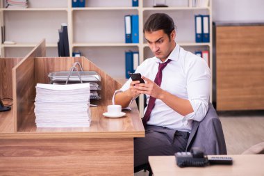 Genç erkek çalışan aşırı çalışmaktan son derece yoruldu.