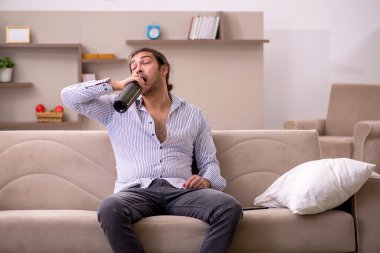 Genç sarhoş adam evde acı çekiyor.