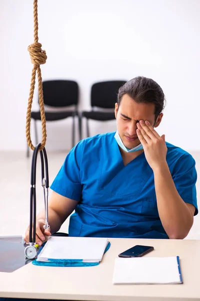 Młody lekarz popełniający samobójstwo w miejscu pracy — Zdjęcie stockowe