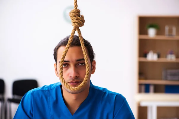 Young male doctor committing suicide at workplace — Stock Photo, Image