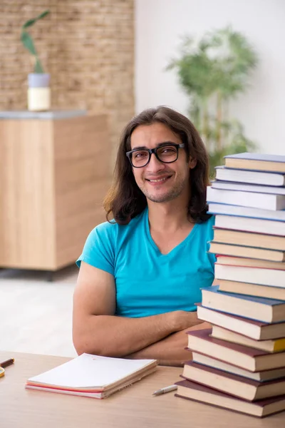 Young male student and a lot of books in the class — Stock Photo, Image