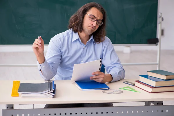 Jonge mannelijke leraar in de voorkant van groene boord — Stockfoto