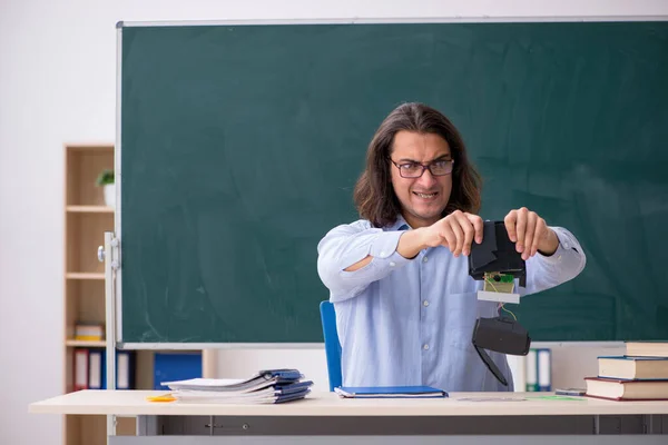 Fiatal férfi tanár a zöld tábla előtt — Stock Fotó