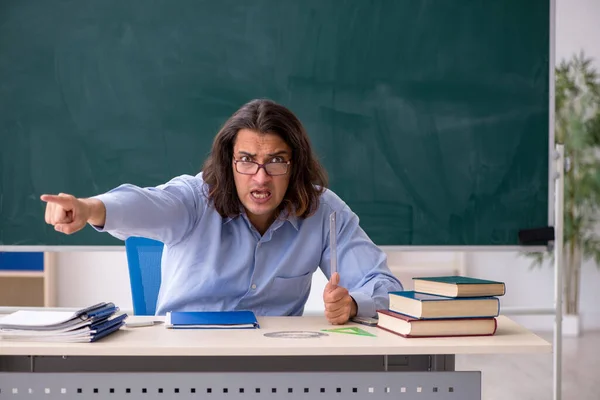 Jonge mannelijke leraar in de voorkant van groene boord — Stockfoto